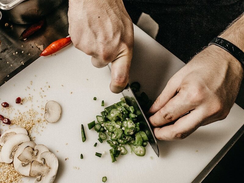 person slicing vegetable